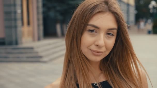 Cute young woman on the street look at camera, steadicam shot. Beautiful portrait fashion summer face female close up — Stock Video