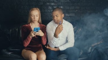 Kahvehanede konuşan çok ırklı çift, vape içen adam ve restoraunt'ta kahve içen kadın, kafede buluşmada pazarlık eden farklı insanlar