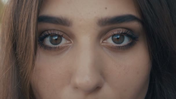 Close-up olhos de bela jovem modelo morena olhando para a câmera. Menina com olhos grandes . — Vídeo de Stock