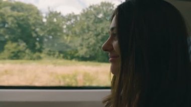 Tren penceresinden dışarı bakan pensive genç bir kadın. Seyahat, ulaşım konsepti