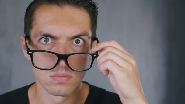 Bliska zszokowany i zaskoczony człowiek bierze od jego okulary i patrzy na kamerę w niespodziankę. — Wideo stockowe
