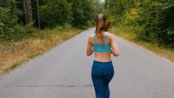 Tillbaka beskåda av ung kvinna löpare utbildning i sommar parkerar. Fitness Girl jogging utomhus. Morgon löpning Concept. — Stockvideo