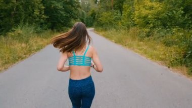 Yaz parkında Genç kadın koşucu eğitim geri görünümü. Fitness kız açık koşu. Sabah çalışan kavramı.