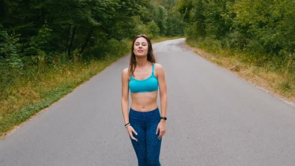 Αθλητισμός νεαρή γυναίκα περπατάει στο δρόμο στο δάσος. γυμναστήριο σε εξωτερικούς χώρους. βολή με σταθερά — Αρχείο Βίντεο