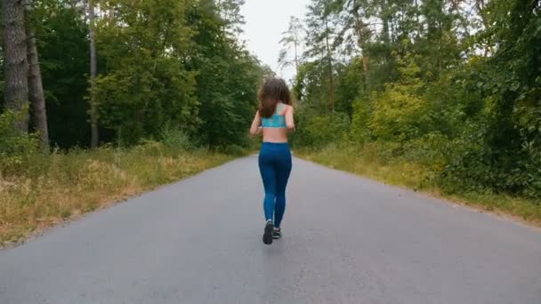 サマーパークでの若い女性ランナートレーニングのバックビュー。屋外でジョギングフィットネスの女の子。モーニングランニングコンセプト. — ストック動画