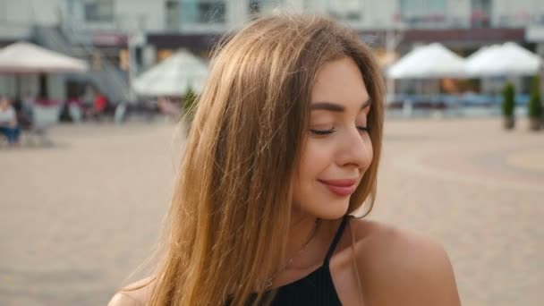 Viso marrone chiaro giovane donna dai capelli guardando la fotocamera da vicino. Ritratto bella donna su urbano città strada sfondo . — Video Stock