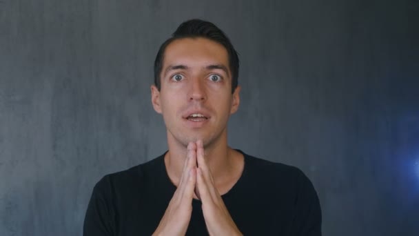 Young man praying to God holding a cross in his hand. Concept of faith and religion — Stock Video