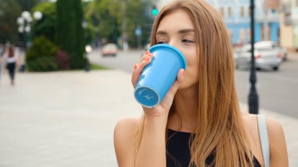 市内の美しい若い女性の肖像。幸せに微笑む。おいしいコーヒーを飲む. — ストック動画