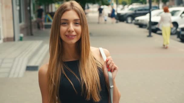 Porträtt av Brown haired ung kvinna tittar på kamera Steadicam skott. Porträtt vacker kvinna på Urban City Street bakgrund. — Stockvideo