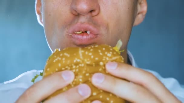 ハンバーガーを食べるクローズアップ男。ファーストフード。チーズバーガー、ハンバーガー、サンドイッチ. — ストック動画
