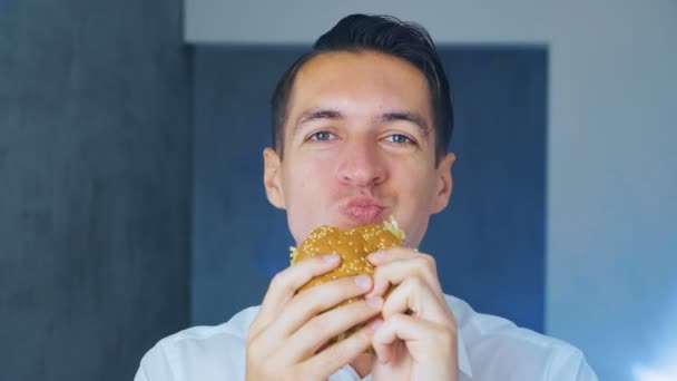 Бізнесмен їсть гамбургер. Швидка їжа. Чізбургер, гамбургер, бутерброд . — стокове відео