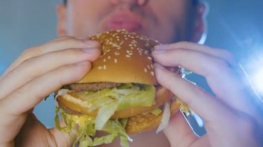 Yakın çekim adam Hamburger yiyor. Hızlı yemek. Cheeseburger, hamburger, sandviç.