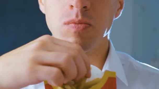 Zeitraffer eines Mannes, der Pommes frites, schädliches und schmackhaftes Fast Food aus nächster Nähe isst — Stockvideo