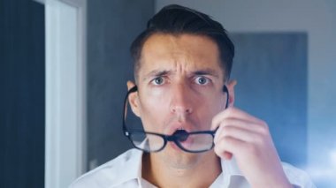 Kafası karışmış iş adamı gözlüklerini, şok edici durumu, yakın çekim yüzünü kapattı. Genç adam şok ve tiksinti