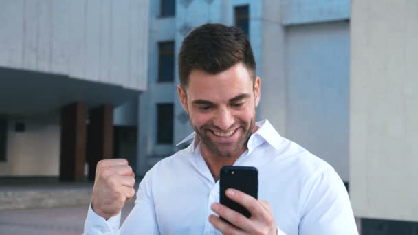 Businessman Menggunakan Smartphone dan Bereaksi terhadap Sukses. Tampan profesional sukses bisnis pria mencapai tujuan pribadi. — Stok Video