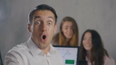 Ofiste meslektaşları ile çevrili dizüstü bilgisayar ile ofis masasında otururken Win Tepki, Heyecanlı İşadamı tarafından Başarı