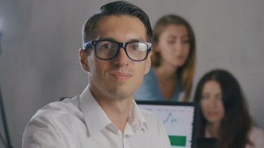 Gözlüklü genç adam gülümseyen portresi. Kurumsal iş ekibi iş ofis toplantısı.