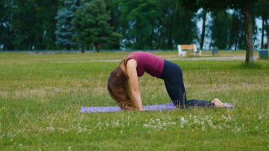 Genç güzel kadın açık havada yoga yapıyor. Sağlıklı yaşam konsepti. Sakinlik ve rahatlama, kadın mutluluğu.