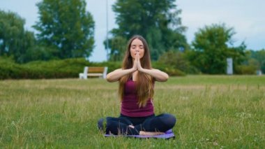 Genç güzel kadın o huzur hissi yaz parkında açık hava eğitimi sırasında meditasyon. Sportif kız sabah ları açık havada yoga yapıyor.