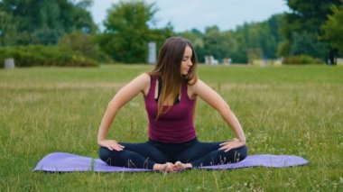 Genç güzel kadın o huzur hissi yaz parkında açık hava eğitimi sırasında meditasyon. Sportif kız sabah ları açık havada yoga yapıyor.