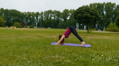 Genç güzel kadın o huzur hissi yaz parkında açık hava eğitimi sırasında meditasyon. Sportif kız sabahları dışarıda yoga yapıyor. Yavaş çekim