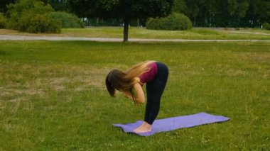 Genç güzel kadın o huzur hissi yaz parkında açık hava eğitimi sırasında meditasyon. Sportif kız sabahları dışarıda yoga yapıyor. Yavaş çekim