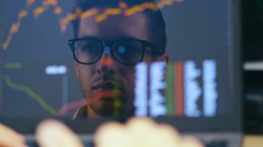 Çift pozlama: Gözlük adam Laptop çalışan ve borsa kontrol eder. Monitörde Yansıma: Başarılı İşadamı Ofiste Bir Laptop Üzerinde Çalışan ve Lezzetli Kahve İçme.