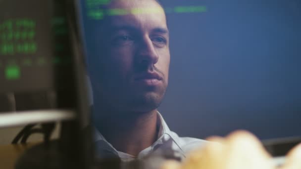 Double Exposure Shot of Man Hacker Programmer working at a laptop. Reflection in monitor: Developer writes green code. — Stock Video