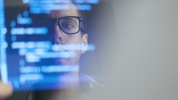 在笔记本电脑上工作的人黑客程序员在眼镜的双重曝光镜头。监视器中的反射：开发人员编写蓝色代码和饮用美味咖啡. — 图库视频影像