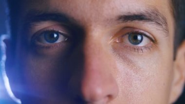 Kamera merceği içine bakarak genç mutlu adamın gözlerini kapatın. Erkek gözlerinin yakın çekim.