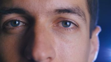 Kamera merceği içine bakarak genç mutlu adamın gözlerini kapatın. Erkek gözlerinin yakın çekim.