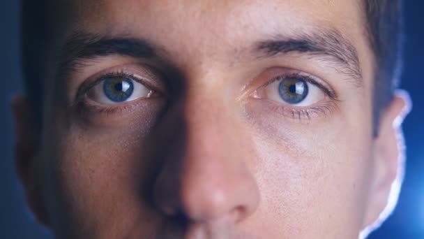 Närbild ögon unga lycklig man tittar in i kameralinsen. Närbild av en manlig ögon. — Stockvideo