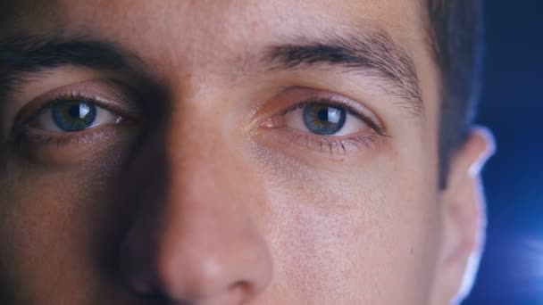 Feche os olhos do jovem homem feliz olhando para a lente da câmera. Close-up de um olho masculino . — Vídeo de Stock