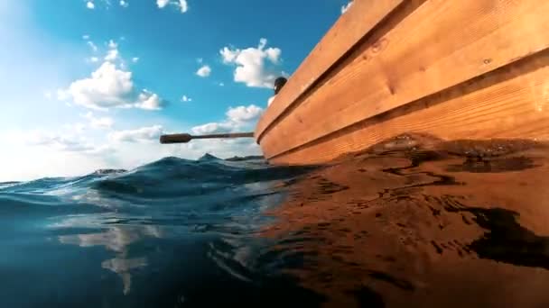 Ο άνθρωπος πλέει σε μια βάρκα κωπηλατεί κουπιά. Κάμερα δίπλα στο νερό. Ταξίδι. — Αρχείο Βίντεο