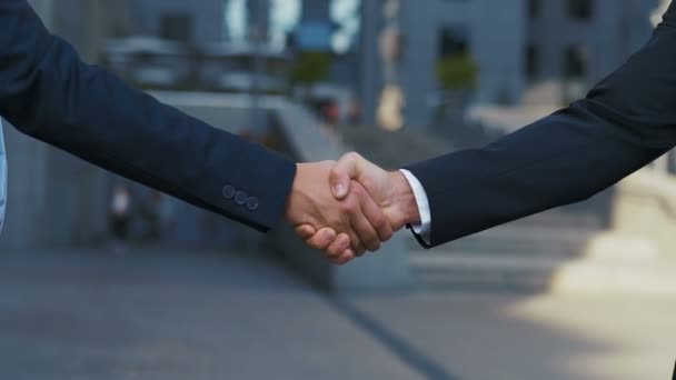 Двоє бізнес-партнерів тремтять руками під час зустрічі. Крупним планом рукостискання двох успішних бізнесменів, які уклали угоду. Повільний рух, невпізнавана людина — стокове відео