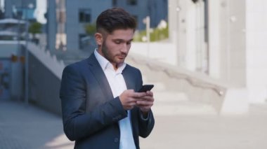 Akıllı Telefon Kullanan ve Başarı Tepkisi Veren İşadamı. Yakışıklı profesyonel başarılı iş adamı kişisel hedeflerine ulaşıyor.