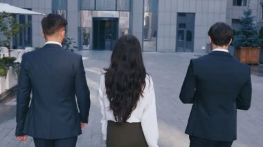 Başarılı İş Adamları İş Tartışmak ve Central Business District yürümek. İki Genç Erkek ve Takım Elbiseli Bir Kadın İletişim ve İş Merkezi Ofis Binası yakınında yürümek.