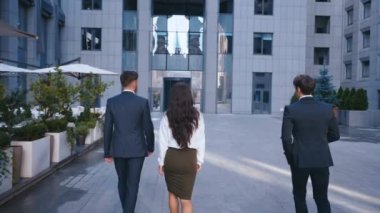 Üç Başarılı İş Adamları: İki yakışıklı Erkek ve Ofis Binasında Kendine Güvenen Yürüyüş Yürüyüşü ile güzel kadın. Klasik takım elbise giyiyor. Genç Kendinden Emin İş Ekibi.