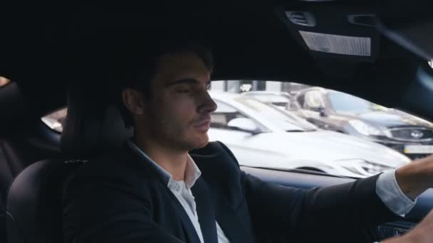 ハンサムなビジネスマンは、車を運転します。若い自信に満ちた男の肖像画は、都市で車を運転しています. — ストック動画