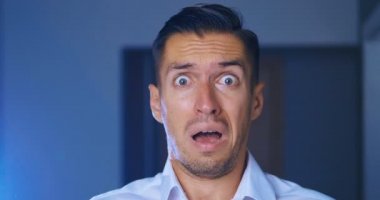 Korkmuş ve korkmuş işadamının elleriyle yüz örde portresi. Adam şok ve çok korkmuş. Korku filmleri izleme kavramı.