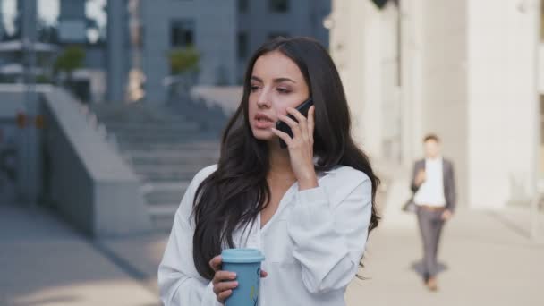 Portret van de succesvolle zakenvrouw die aan de telefoon praat tijdens een koffiepauze. Mooie vrouwelijke Executive staande buiten in de buurt van kantoorgebouw Business Center. — Stockvideo