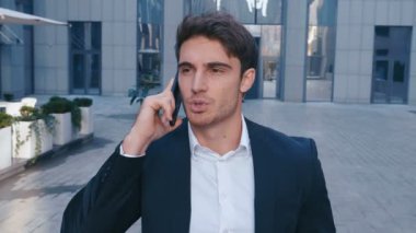 İş Mahallesi Sokaklarında Yürüyen Ve Cep Telefonuyla Konuşan Genç İş Adamı. İşten sonra eve gitmek