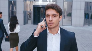 İş Mahallesi Sokaklarında Yürüyen Ve Cep Telefonuyla Konuşan Genç İş Adamı. İşten sonra eve gitmek