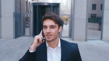 Yakışıklı İş Adamı İş Mahallesi Sokaklarında Yürüyor ve Cep Telefonuyla Konuşuyor. İşten sonra eve gitmek