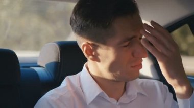 Depresif adamın taksiye bindiği bir portre. İşadamı üzgün ve üzgün, o bir sürücü ile bir araba sürüyor. İş yerinde stres veya iş sorunları.