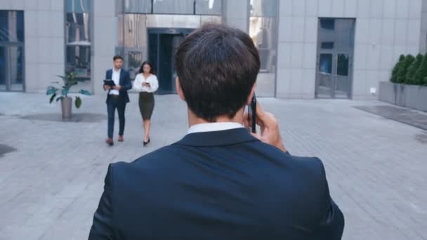 Arka dansı kendine güvenen işadamı telefonla konuşuyor ve ofis merkezinde sokakta yürüyor. Başarılı iş adamı ofiste işe gidiyor — Stok video