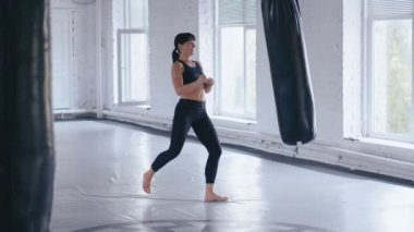 Kickboks profesyonel atlet kadın spor salonunda yumruk torbası tekmeler. Spor salonunda Atletik Taekwondo kadın eğitimi.