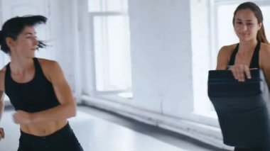 Atletik Kadın, Partnerinin Tuttuğu Kum Torbasına Tekmelerini Yetiştiriyor. Taekwondo veya Kickboks eğitimi. Spor Salonunda İki Sporcu Kadın Eğitimi