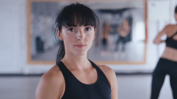 Портрет спортивной женщины, уверенно смотрящей в камеру в спортзале. Привлекательная спортсменка после тренировки в фитнес-зале крупным планом . — стоковое видео