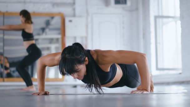 Atlética hermosa mujer haciendo flexiones en el suelo en el gimnasio Cross Fitness. Deportiva haciendo ejercicio en el gimnasio. Entrenamiento Crossfit . — Vídeo de stock